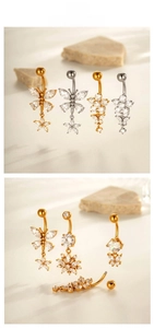 Detail of stainless steel belly rings with butterfly and flower zircon pendants