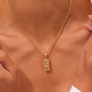 Close-up of golden tarot moon pendant on twisted rope chain worn by a model