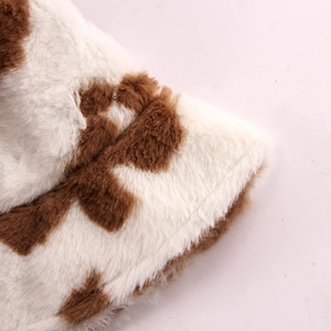 Close-up of fluffy faux fur material with brown heart patterns on cow print bucket hat