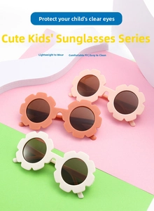 Three colorful flower-shaped children's sunglasses with dark lenses on a pastel background