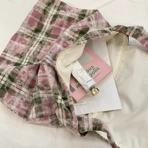 Détail d'un sac cabas en toile à carreaux rose et vert avec poche intérieure zippée