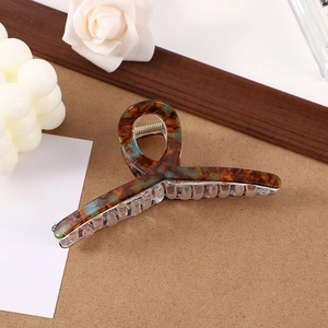 Detailed close-up of a brown and blue striped acetate hair claw clip with floral accents