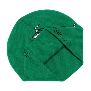 Détail macro du bonnet en tricot vert herbe avec motif jacquard noir et blanc et texture