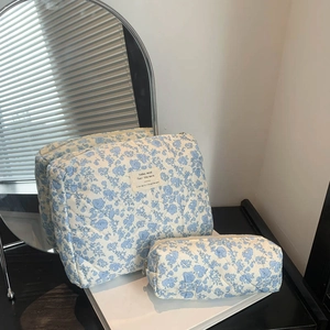 Set of two quilted blue floral cosmetic bags with large rectangular and small cylinder shapes