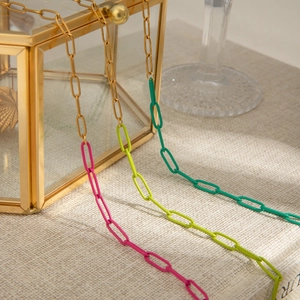 Close-up of tricolor stainless steel oval link chain in gold, pink, and green hues