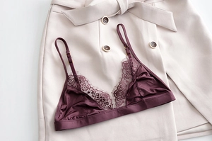 Dettaglio del reggiseno in raso viola scuro con pizzo ciglia e spalline sottili