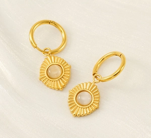 Detail of 18K gold stainless steel earrings with cat eye stone on silk background