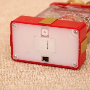 Detail view of the Christmas snow globe base with battery compartment and power switch