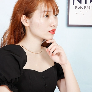 Elegante vergulde lipketting gedragen door een model in een minimalistische stijl voor dames