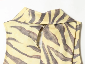Detailed view of the rear neckline button closure on a brown zebra print sleeveless dress