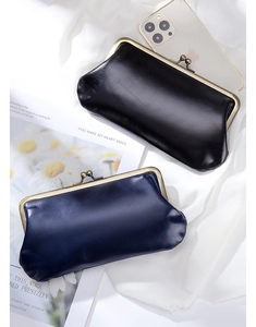 Chic black and navy vintage leather frame clutch bags displayed on white fabric