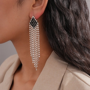 Close-up of model wearing silver tassel rhinestone drop earrings with black geometric accents