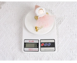 Pink angel Christmas ornament with tulle skirt and golden wings weighing 8g on a scale