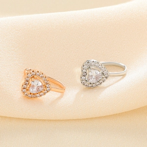 Macro detail of heart-shaped copper nose clips with pavé cubic zirconia in rose gold and silver
