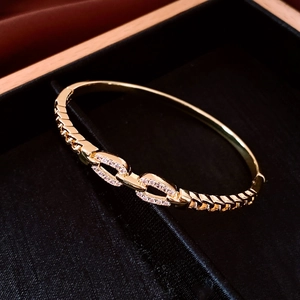 Macro detail of gold-plated double-ring bracelet with pavé crystals in luxury box
