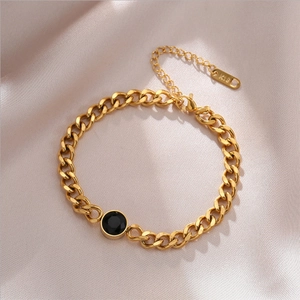 Gold-plated titanium steel bracelet featuring a black round gem on elegant satin background