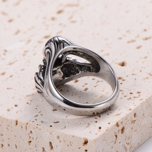 Macro detail of silver vintage punk rock ring on natural stone texture background