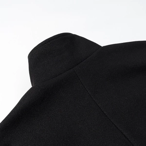 Vue détaillée du col noir élégant et de la couture de l'épaule sur la veste en laine