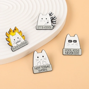 Macro detail of cartoon cat enamel pins featuring humorous quotes and metal craftsmanship