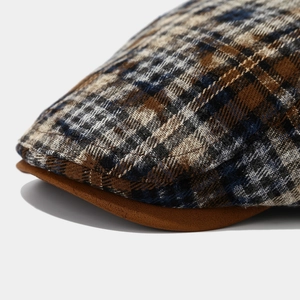 Detailed macro view of tie-dye plaid fabric texture and stitching on the retro beret cap