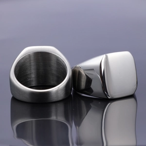 Detail of two silver square signet rings showing mirror polish and brushed finish