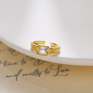 Detailed macro shot of an 18k gold-plated ring with a rectangular crystal and grooved texture