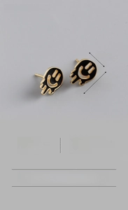 Detailed view of S925 sterling silver melting smiley face stud earrings with black enamel
