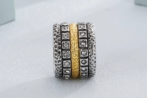 Macro shot of mixed metal stacked ring with hammered gold, silver bands and zircon crystals