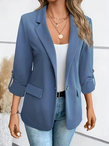 Detail of blue casual blazer with rolled sleeves and decorative flap pockets for women