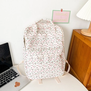Detail of floral canvas backpack with pink and green patterns on a desk background