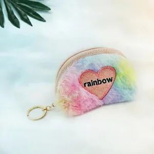 Macro shot of colorful plush rainbow coin purse with pink glitter heart and zipper