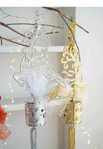 Dettaglio di campanelli a forma di renna oro e argento con fiocchi e stelle intagliate