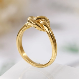 Macro shot of gold-plated stainless steel knot ring with smooth polished finish