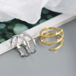 Detail of twisted branch texture rings in silver and gold finishes with natural bumps