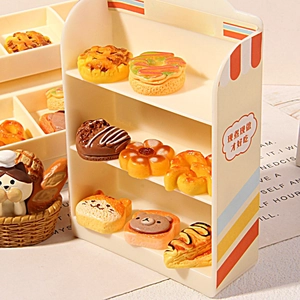 Miniature resin bakery display set with cat chef figurine and tiny pastries on a shelf