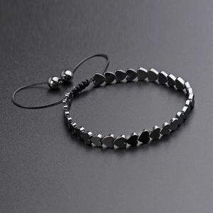 Detail of adjustable woven cord bracelet featuring heart-shaped hematite stone beads