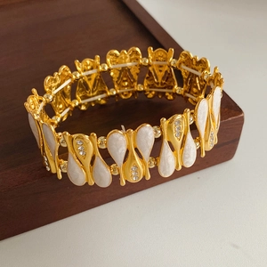 Detail of vintage gold bracelet featuring white mother-of-pearl and crystal accents