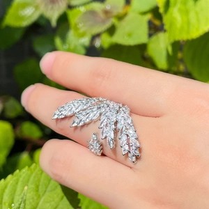 Adjustable silver ring with marquise-cut zircon angel wings on a hand outdoors
