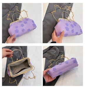 Detail of purple floral embroidery, gold handle and chain on lace evening clutch bag