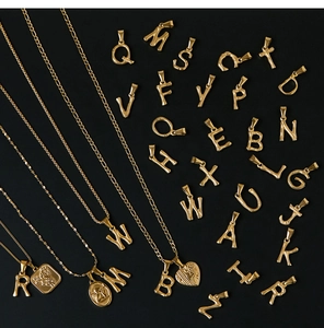 Detailed view of 18K gold plated bamboo style alphabet pendants on varied metal chains