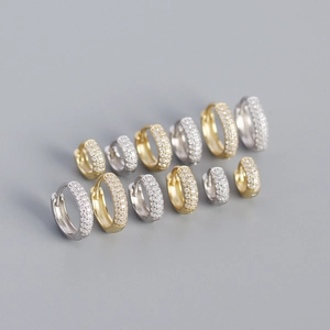 Macro shot of silver and gold pave huggie earrings with sparkling cubic zirconia stones
