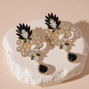 Macro detail of vintage floral drop earrings with black pear-shaped crystals and gold trim