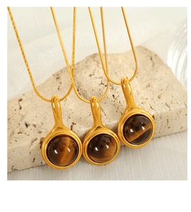 Detailed macro view of golden tiger eye stone pendants on sleek snake chain necklaces
