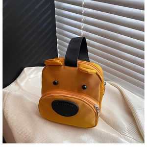 Detail of yellow bear-shaped nylon handbag featuring front pocket and black handles