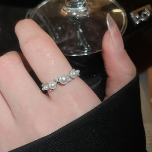 Close-up of French-style pearl and zircon ring with silver finish on a finger