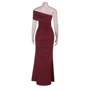 Detail view of burgundy off-shoulder gown featuring draped ruffles and mermaid silhouette