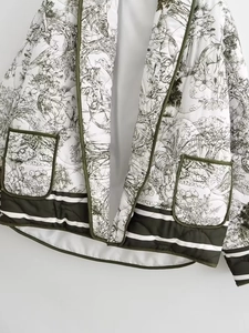 Détail de veste matelassée blanche avec motif Toile de Jouy vert et ourlet rayé