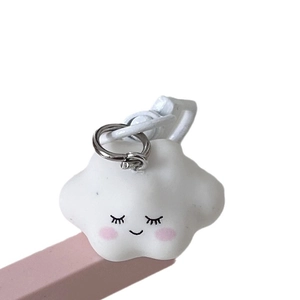 Cute white cloud keychain with a smiling face on a pink stand, stylish accessory