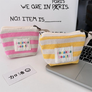 Close-up of canvas striped mini makeup pouches in pink and yellow with zipper closure