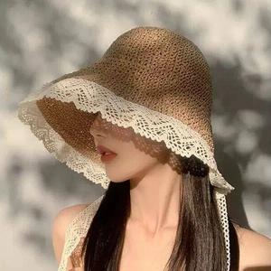Detailed close-up of handmade straw hat with delicate white lace trim and woven texture